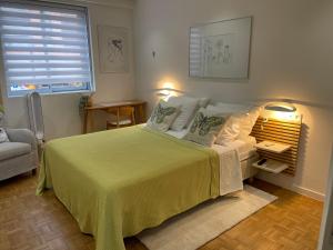 尼斯Le Copacabana Riviera的一间卧室配有一张带黄色毯子的大床