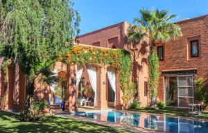 马拉喀什Magnificent Villa "Golf Amelkis"的大楼前带游泳池的房子