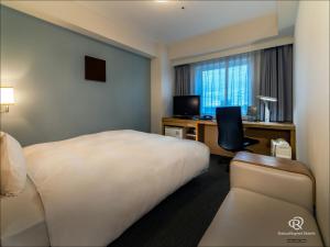 筑波筑波大和鲁内酒店的酒店客房配有一张床和一张带电脑的书桌