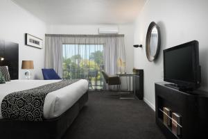 陶朗加阿米蒂奇酒店及会议中心的配有一张床和一台平面电视的酒店客房