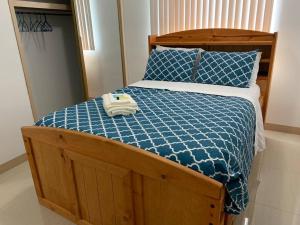 HagatnaPrivate/Central 3 Bedroom Home的一张带蓝色棉被的床和两张毛巾