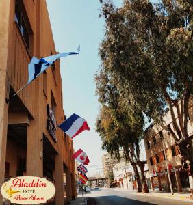 贝尔谢巴阿拉丁贝尔谢巴酒店的悬挂在建筑物一边的一组旗帜