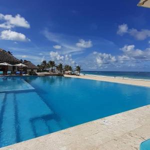 蓬塔卡纳Apartamento 120 Jardin Privado Cana Rock的海滩旁的大型蓝色游泳池
