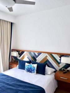 蓬塔卡纳Apartamento 120 Jardin Privado Cana Rock的一间卧室配有一张蓝色的床和木制床头板