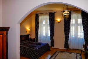 布拉索夫卡萨瓦格纳酒店的一间卧室设有一张床和两个大窗户