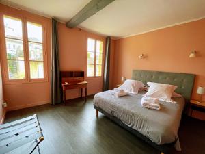 圣艾米隆La Petite Fontaine的一间卧室配有一张床,上面有两条毛巾