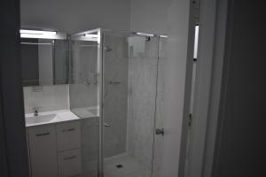 德尼利昆里维亚那汽车旅馆的一间带玻璃淋浴和水槽的浴室