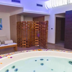 切萨雷奥港Baiamalva Resort Spa的一个带砖墙的客房内的按摩浴缸