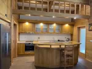 班斯科Villa Naya, Pirin Golf & Spa的厨房配有木制橱柜、水槽和炉灶。