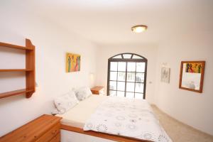 查德尔帕罗奥隆达之家别墅的白色的卧室设有床和窗户