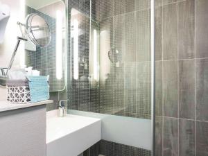 马赛宜必思马赛伯尼维尼卡兰奎斯勒斯普利兹酒店的浴室配有盥洗盆和带镜子的淋浴