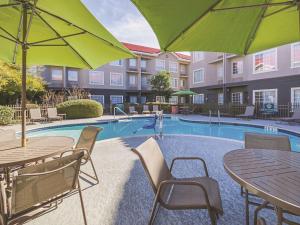 奥斯汀奥斯汀拉金塔套房酒店的一个带桌子和遮阳伞的游泳池
