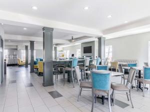 堪萨斯城堪萨斯城机场拉昆塔套房酒店的一间带桌椅的用餐室和一间酒吧