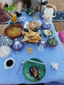 梅尔祖卡Family Moroccan House的一张蓝色桌子,上面放着盘子和薯条