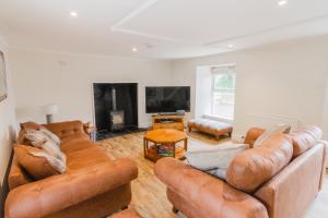 希河谷Dalnaglar Castle Estate的客厅配有棕色真皮沙发和电视