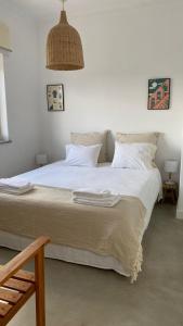 科武港Porto Covo Bay House的一间卧室配有一张带白色床单的大床