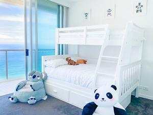 黄金海岸Air on Broadbeach Beachfront 2Level stunning apartment with 180 degree views的卧室配有白色双层床,饲养着动物