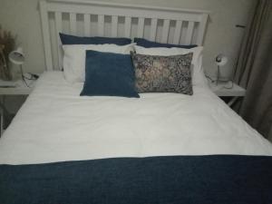 比勒陀利亚Private Room Chez Khanyi Homestays的一张带蓝色和白色枕头的床