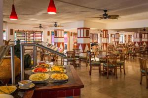 拉纳韦贝Royal Decameron Club Caribbean Resort - All Inclusive的餐桌上放有盘子的餐厅