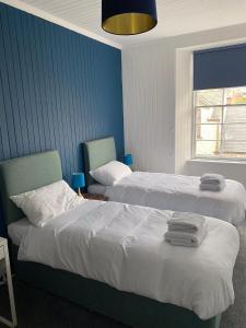 KirkconnelQueensberry arms hotel的两张位于酒店客房的床,拥有蓝色的墙壁