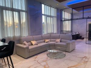 鲁昂Golden Suite - JACUZZI SAUNA的带沙发和玻璃桌的客厅