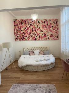 鲁昂Golden Suite - JACUZZI SAUNA的卧室的墙上挂着一幅大花画