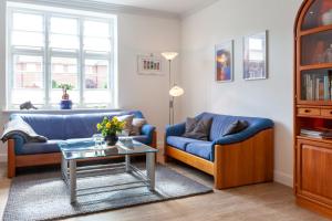 弗伦斯堡Stadthaus Jürgensby的客厅配有2张蓝色的沙发和1张桌子
