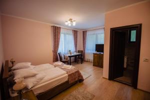 AnieşCasa Măiereană的一间卧室配有一张床、一张桌子和一张书桌