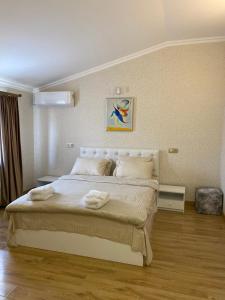 姆茨赫塔Hotel 12 Tve的卧室配有一张带白色床单和枕头的大床。