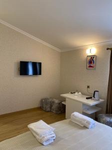 姆茨赫塔Hotel 12 Tve的酒店客房配有一张床、一张书桌和一台电视。