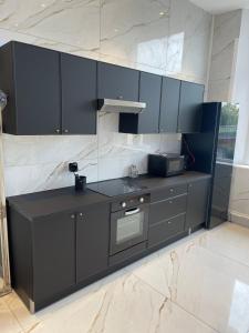鲁昂Golden Suite - JACUZZI SAUNA的厨房配有黑色橱柜和微波炉