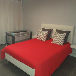 莫尔比耶Agréable appartement的一间卧室配有红色的床和枕头