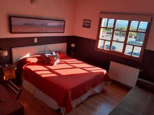 埃尔卡拉法特拉斯阿凡达戴斯酒店的红色卧室配有一张带红色毯子的床