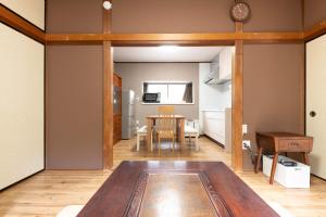 箱根箱根湯本 川風荘 - Hakone Yumoto Kawakazesou的一间带桌子的客厅和一间厨房