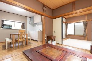 箱根箱根湯本 川風荘 - Hakone Yumoto Kawakazesou的一间带桌子的客厅和一间餐厅