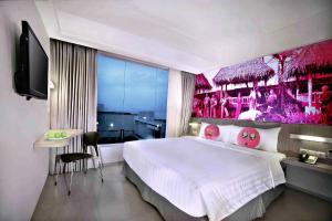 加鲁特希曼努克贾璐酒店的一间卧室配有一张带粉红色墙壁的大床