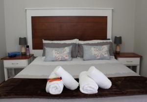 吕德里茨Tranquility Self Catering的一间卧室配有带3条白色毛巾的床