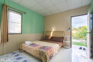 Ban Noen Hom诺普勒凯亚花园度假屋的一间卧室设有一张床和一个大窗户