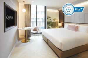 曼谷The Quarter Ploenchit by UHG - SHA Extra Plus的酒店客房配有一张床铺和一张桌子。