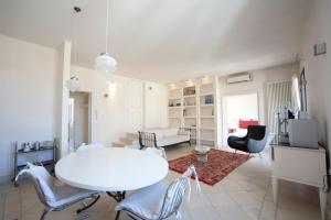 莱切Apartments Bedlecce的白色的客厅配有白色的桌子和椅子
