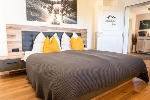 格英Apartment zu Hollenau的一间卧室配有一张带黄色枕头的大床