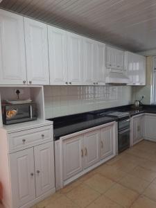 MirikSEWANS PLACE Homestay的厨房配有白色橱柜和黑色台面