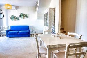 托雷拉皮罗Villa Arya - Piscina privata的客厅配有桌子和蓝色沙发