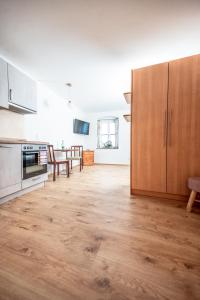 哈莱恩Pension-Cafe-Konditorei Mikl的铺有木地板的厨房,配有木制橱柜。