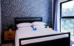约翰内斯堡Stay Ulo at Atholl Gate的一间卧室配有一张蓝色和白色壁纸的床