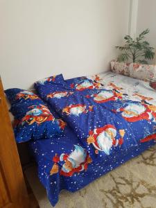 彼得罗沙尼Garsoniera Mihaela的一张带蓝色棉被的床