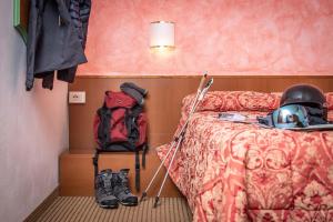 摩德纳迪-坎皮格里奥伊塔洛酒店的卧室配有头盔和床边背包