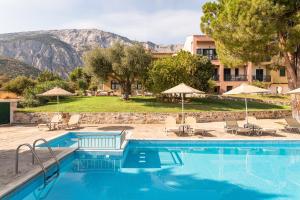 马拉松坎博斯Hotel Ledra的一个带椅子和遮阳伞的游泳池以及一个度假村