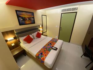 孟买Hotel Regal International - Near Mumbai International Airport Andheri East的一间卧室配有一张带红色枕头的大床