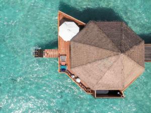 加弗阿利夫环礁Mercure Maldives Kooddoo Resort的一艘水中带雨伞的小船